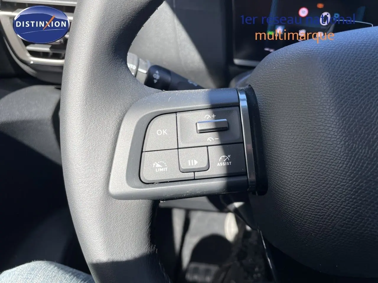 Gros plan sur les commandes au volant côté gauche du Citroën C4 Hybrid 145ch bleu Eclipse Metal, 2026.