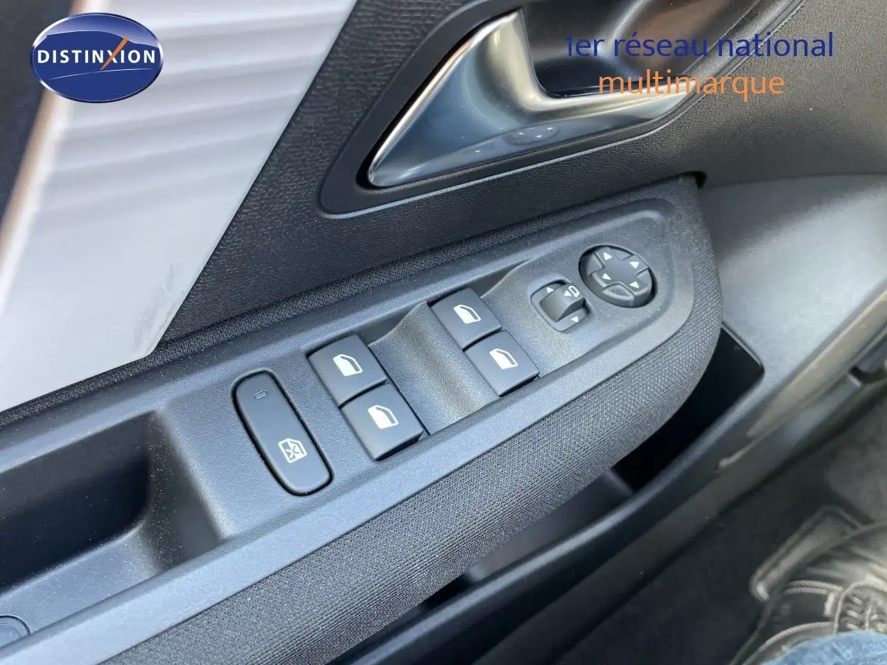 Gros plan sur les commandes des vitres et rétroviseurs côté conducteur d'une Citroën C4 hybride 2026, intérieur noir.