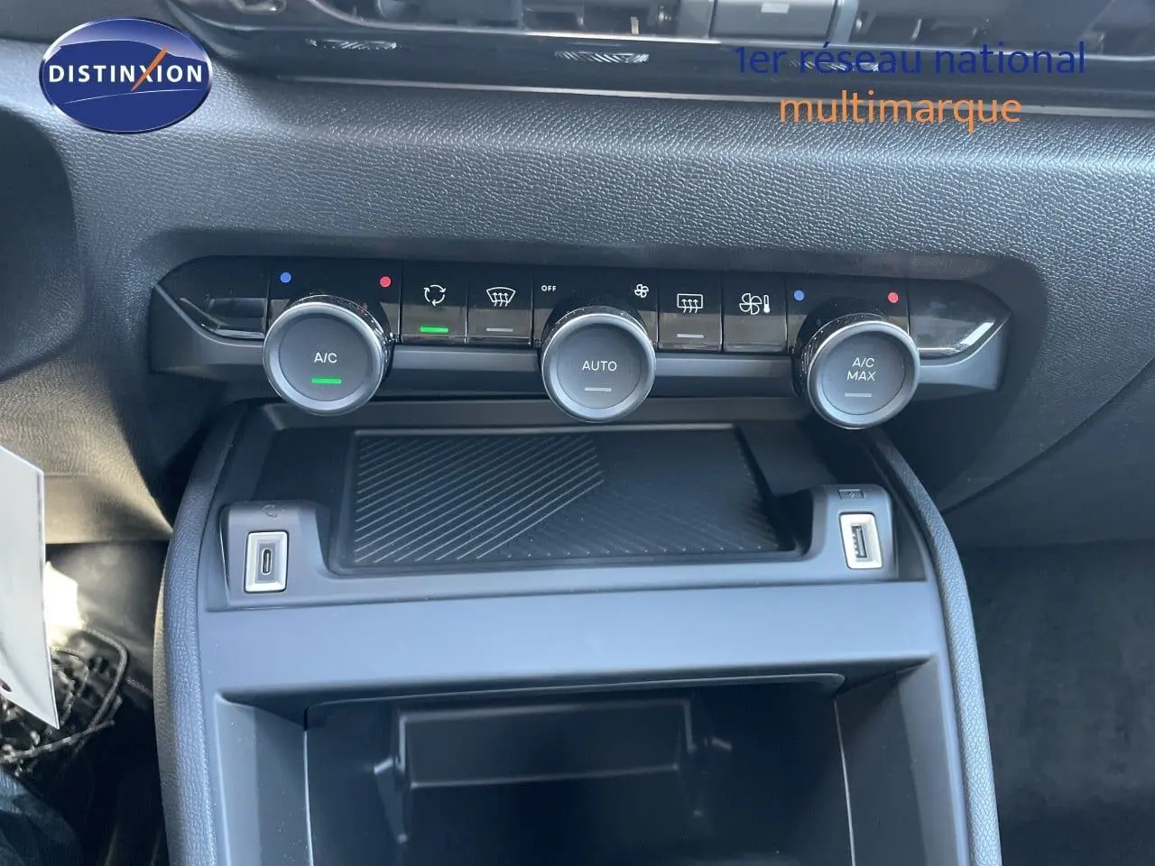 Gros plan sur la console centrale de la Citroën C4 Hybrid 2026, montrant les commandes de climatisation et ports USB.