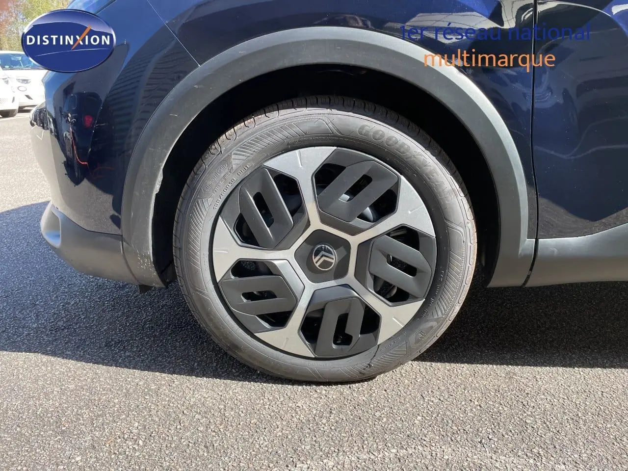 Gros plan sur la roue avant droite d'une Citroën C4 bleu Eclipse Metal avec jante au design moderne.