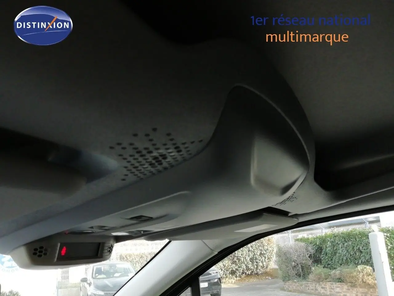 Vue intérieure du toit et pare-soleil côté conducteur d’un Citroën Berlingo XL blanc, avec rétroviseur et capteur lumineux.