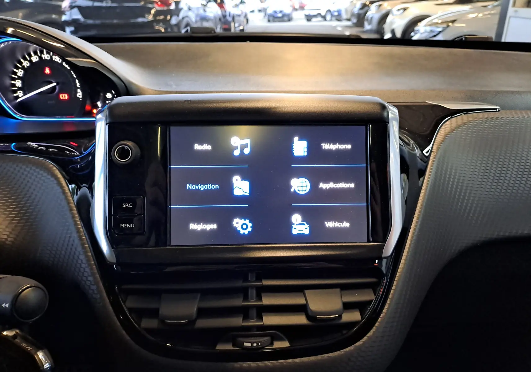 Écran tactile central du tableau de bord d'une Peugeot 2008 gris 2019, avec menu multimédia et navigation visible.