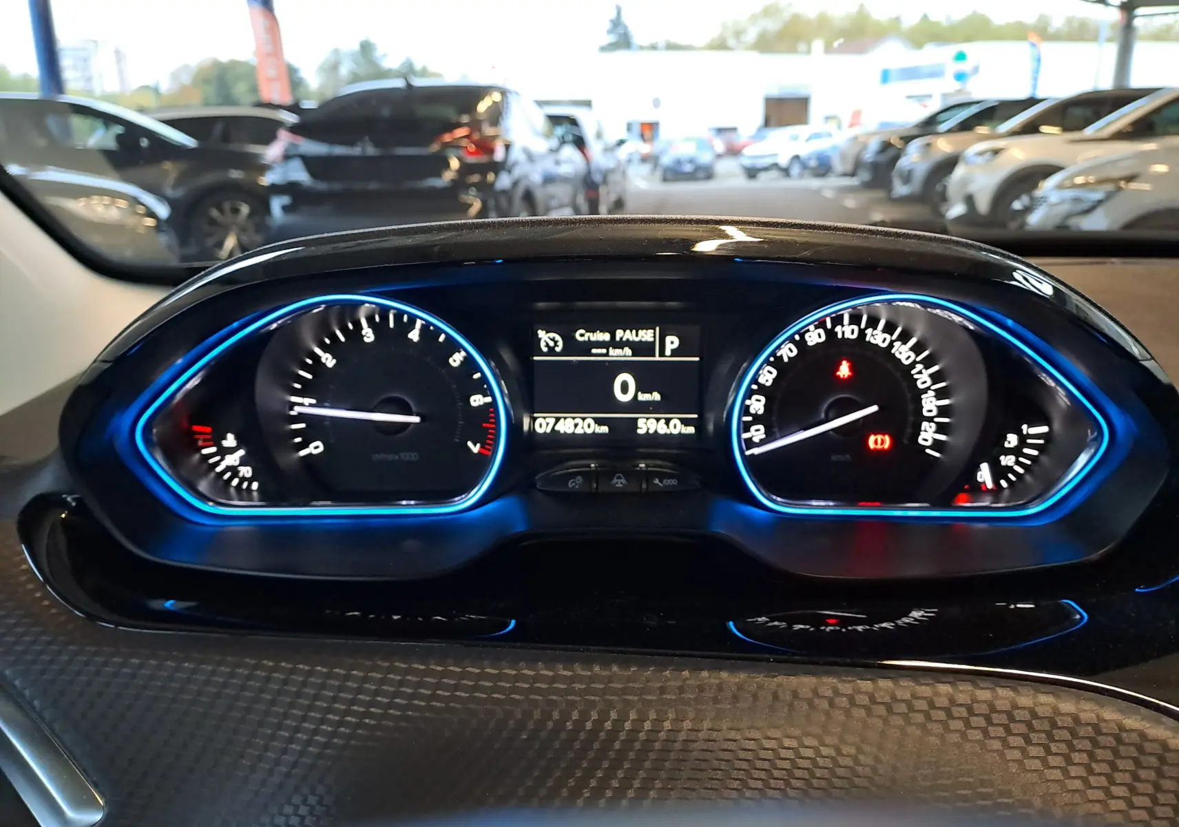 Tableau de bord du Peugeot 2008 2019 avec compteurs rétroéclairés en bleu et affichage digital au centre.