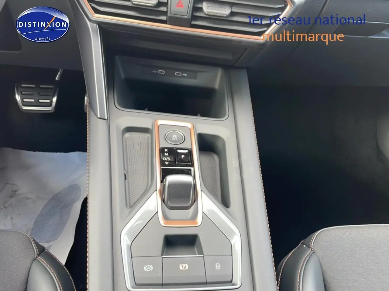 Vue intérieure centrée sur la console centrale du CUPRA Formentor gris magnétique avec levier de vitesses automatique et finitions cuivrées.