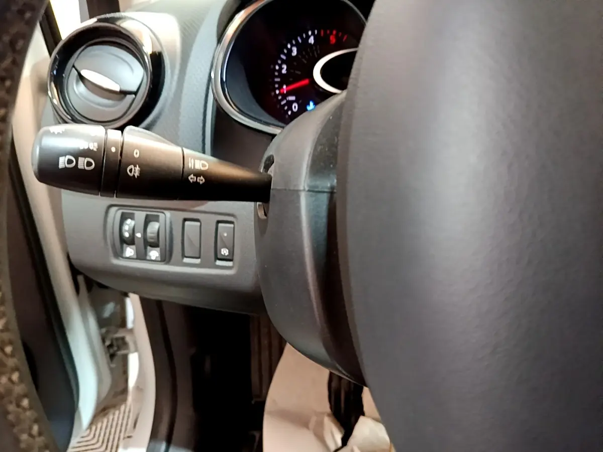 Vue rapprochée du volant cuir et des commandes d'éclairage à gauche dans une Renault Clio Zen Energy dCi 75 blanche de 2016.