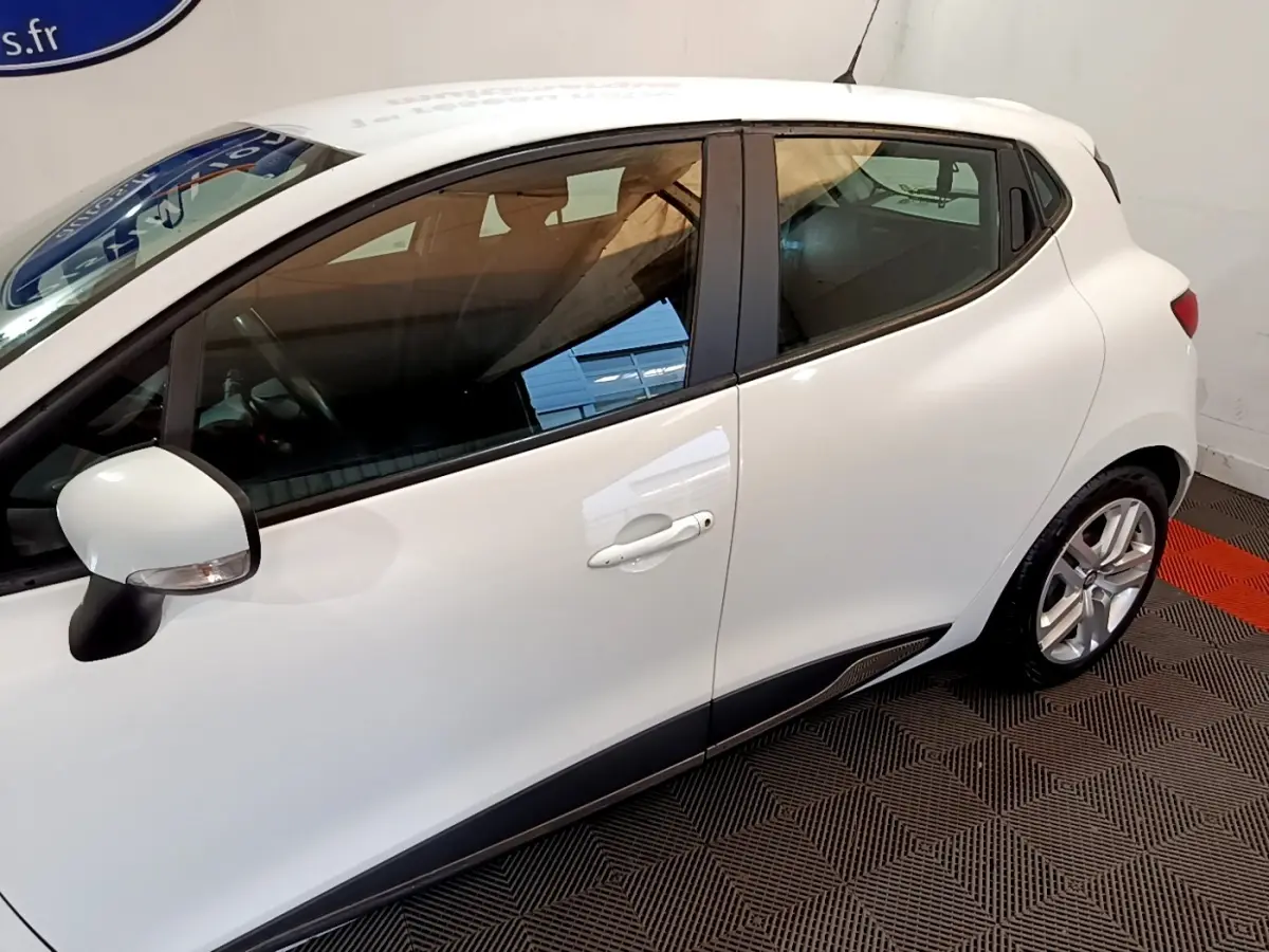 Vue latérale droite d'une Renault Clio Zen Energy dCi 75 blanche avec rétroviseur et jantes visibles.