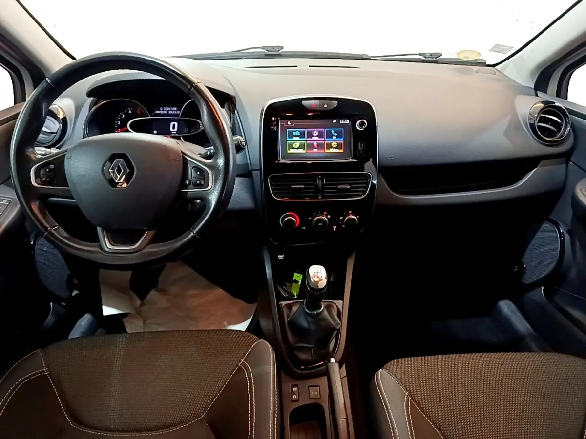 Vue intérieure avant de la Renault Clio Zen Energy dCi 75 2016, volant cuir noir et écran tactile central coloré.