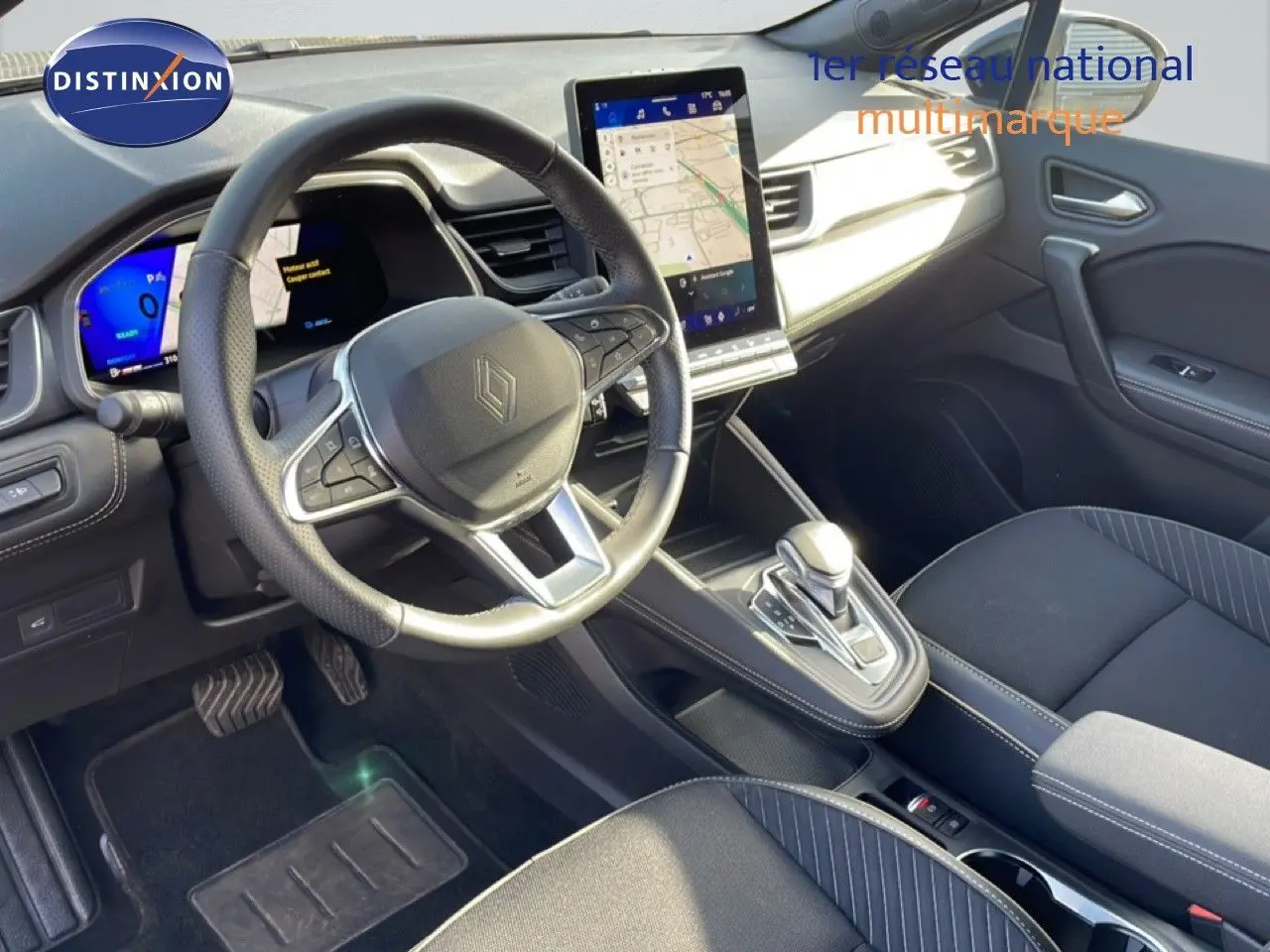 Vue intérieure côté conducteur du Renault Symbioz gris cassiopée, avec volant multifonction et écran tactile central vertical.