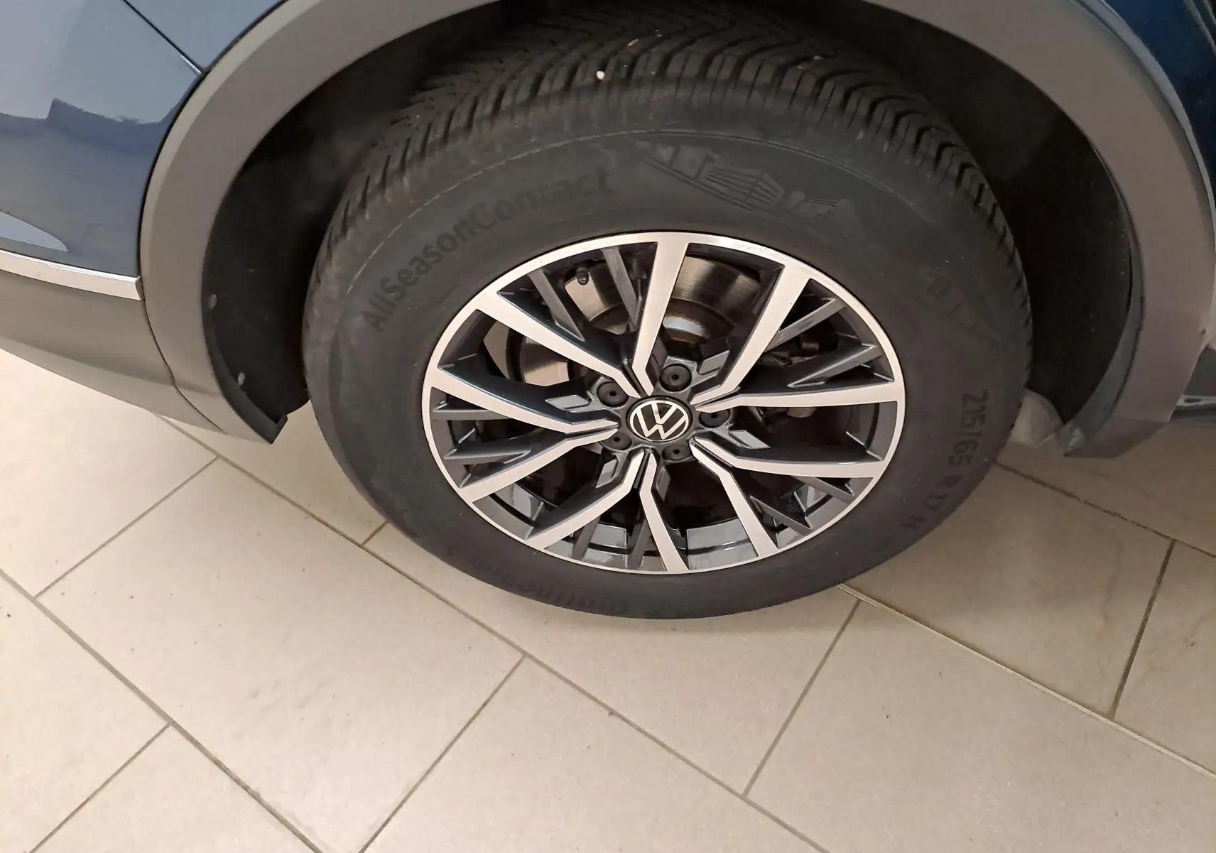 Gros plan sur la jante 17'' Tulsa noire et argent du Volkswagen Tiguan Nightshade Blue, côté arrière droit.