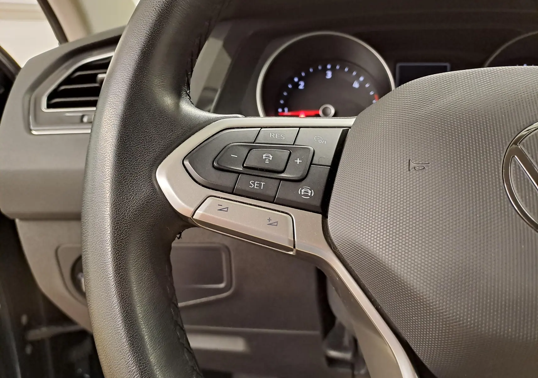 Vue rapprochée du volant multifonction noir du Volkswagen Tiguan 2023 avec commandes de régulateur de vitesse.