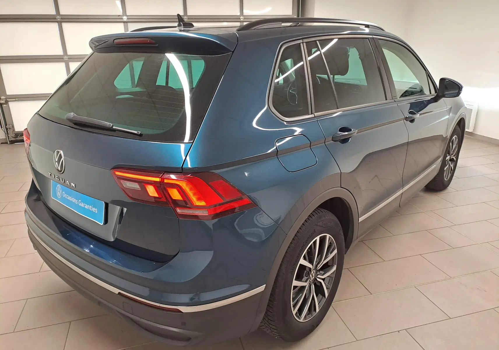Vue 3/4 arrière droite du Volkswagen Tiguan 2023 bleu Nightshade avec jantes 17'' Tulsa et crochet d'attelage escamotable.
