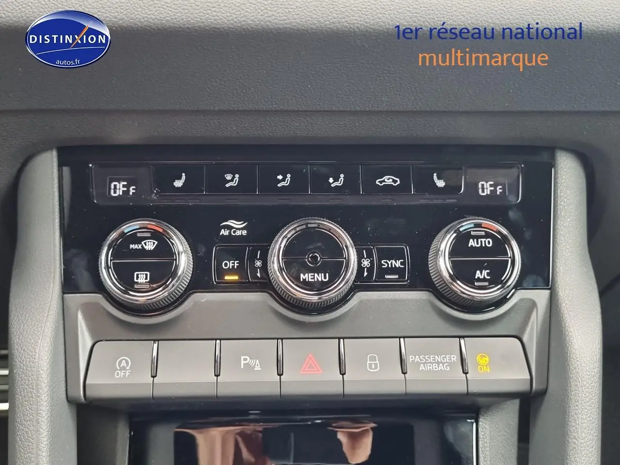 Gros plan sur la console centrale du Skoda Karoq noir 2025, mettant en valeur les commandes de climatisation et boutons fonctionnels.