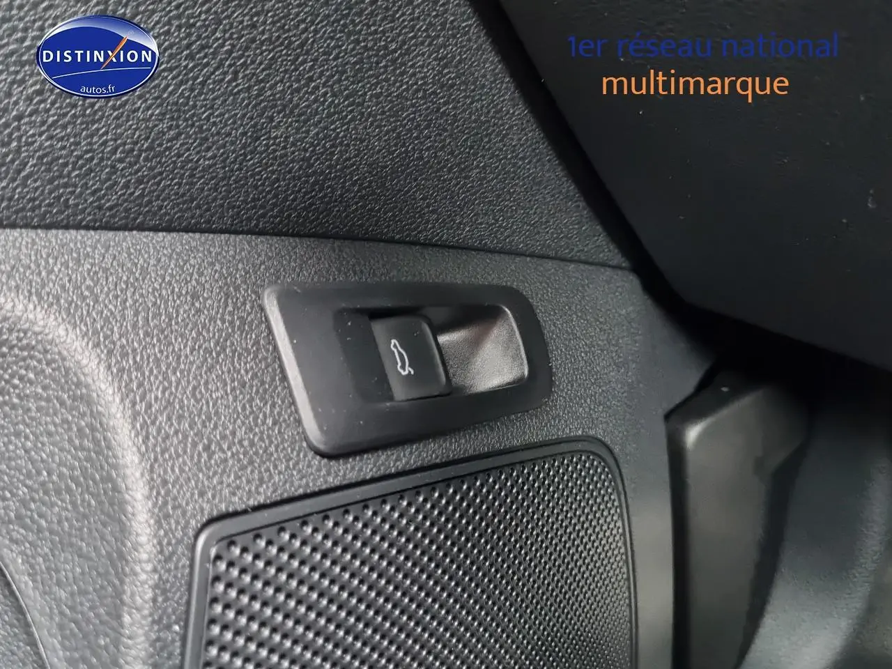 Détail intérieur du bouton d'ouverture de coffre sur la portière d'un Skoda Karoq noir 2025.