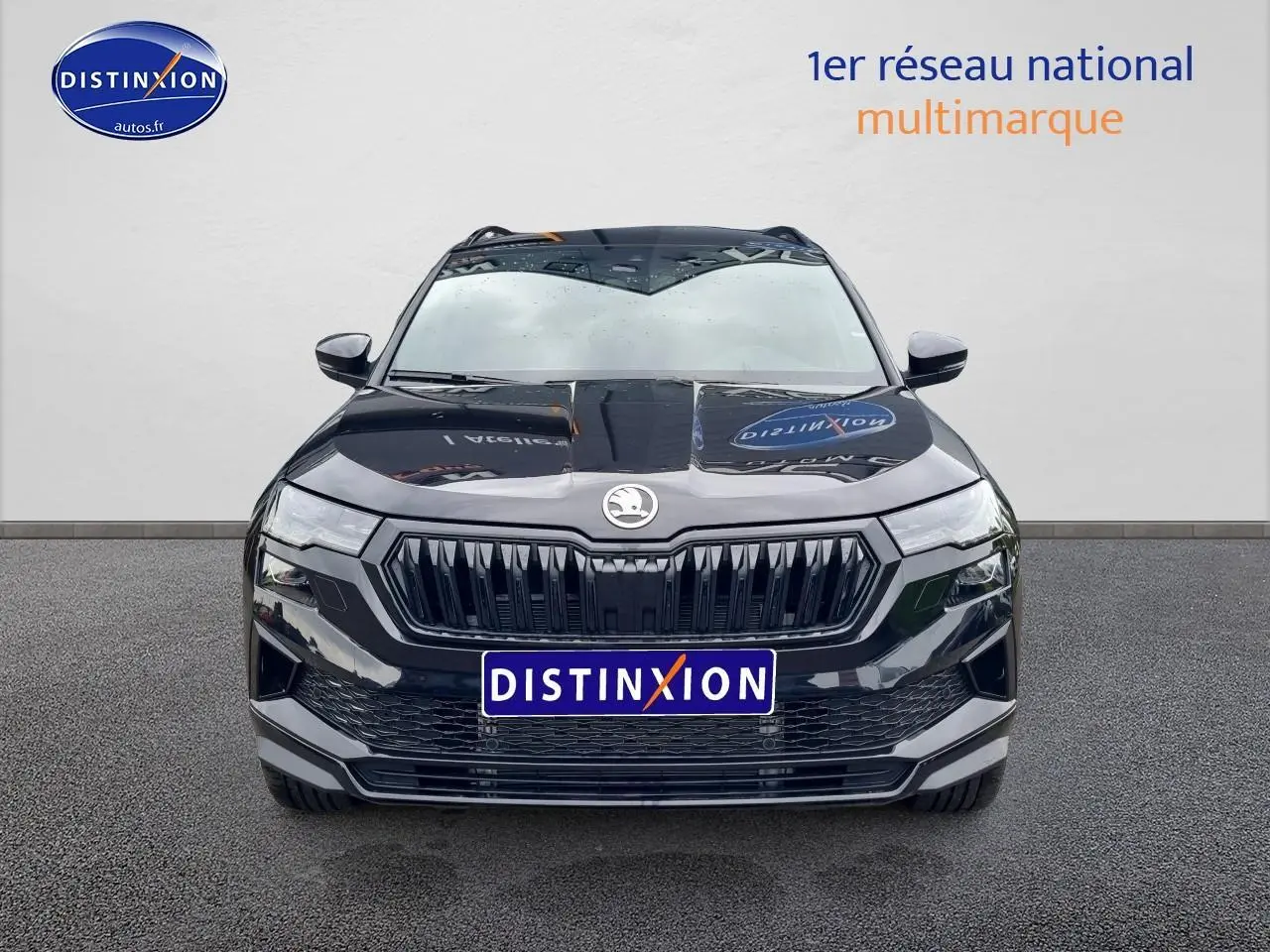 Vue avant d’un Skoda Karoq noir 2025 avec calandre marquée et phares LED, sur fond neutre gris.