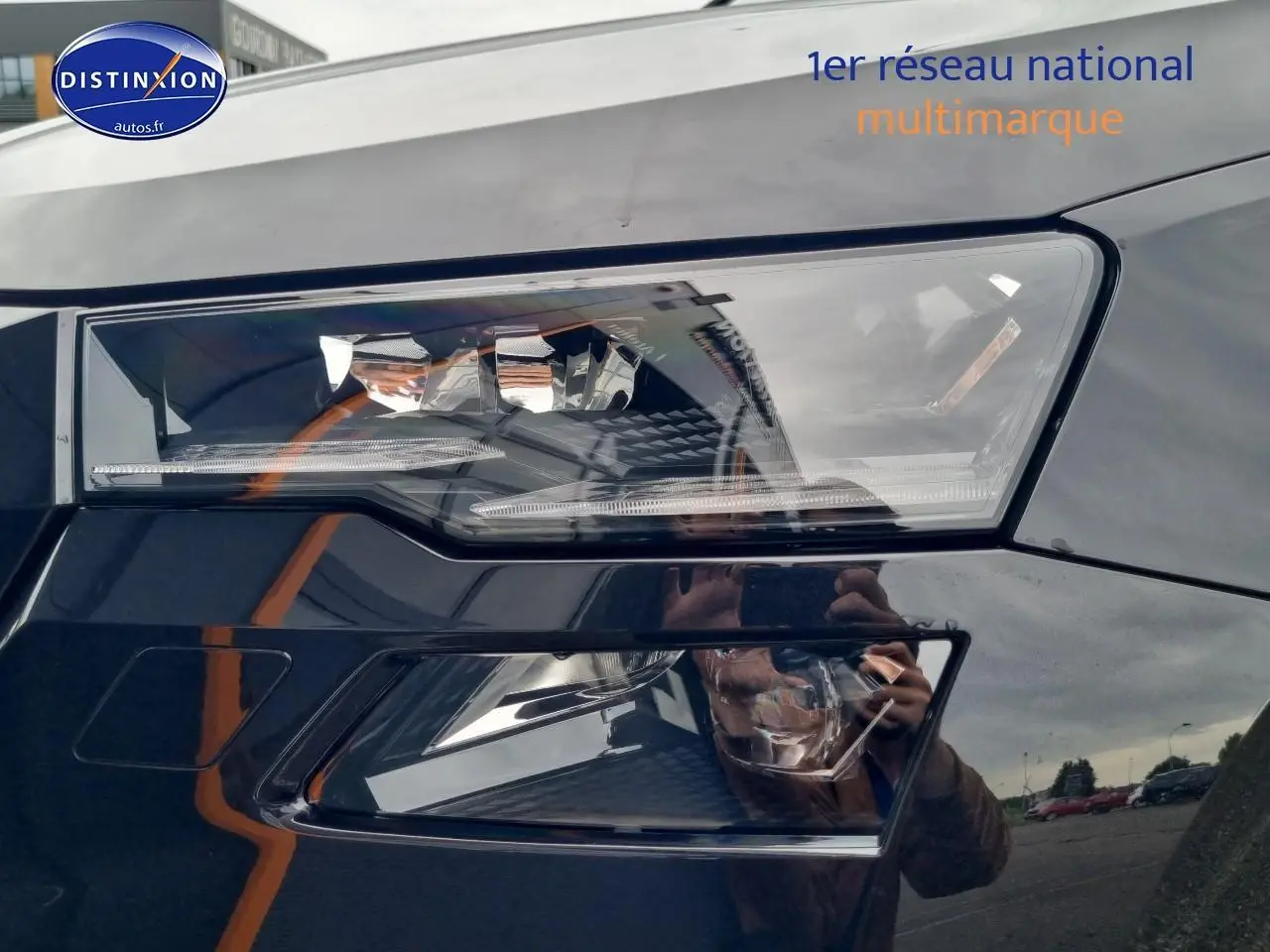 Gros plan sur le phare avant droit noir brillant du Skoda Karoq 2025 avec détails LED et reflets environnants.