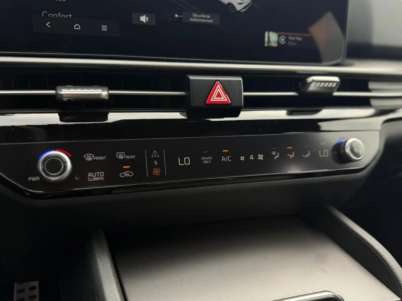 Détail de la console centrale noire brillante du Kia Sportage 2026, montrant les commandes tactiles de climatisation automatique.