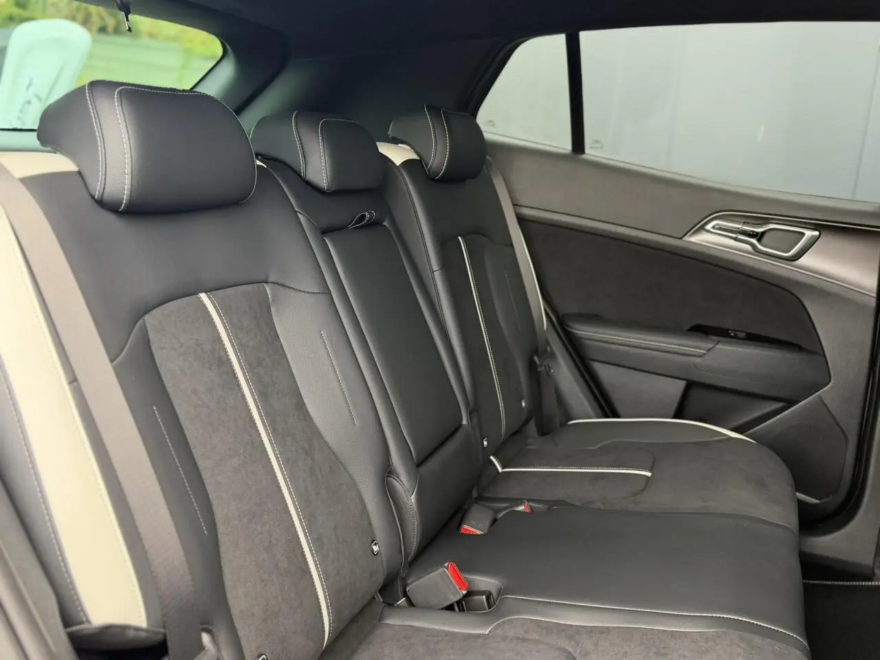 Vue latérale intérieure des sièges arrière bi-ton noir et gris du KIA Sportage 2026 finition GT-line.