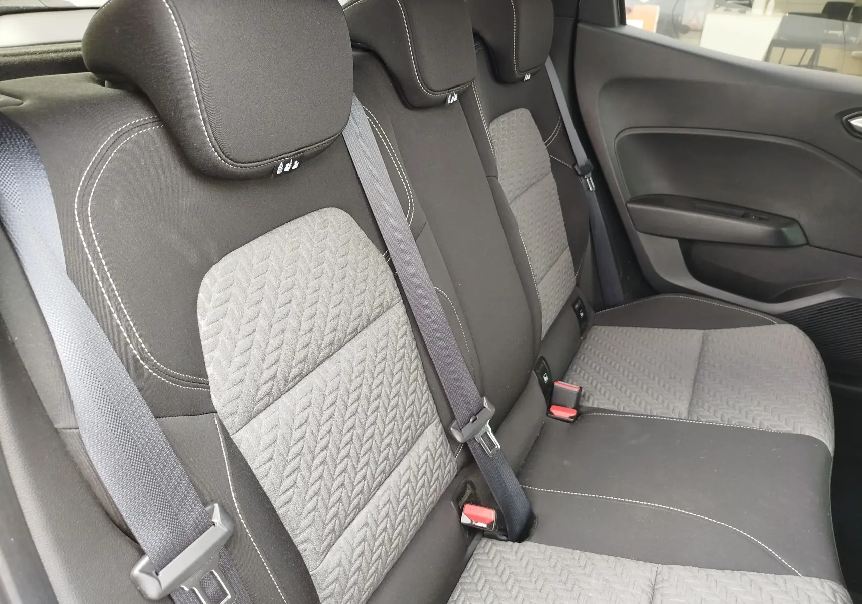 Vue latérale droite des sièges arrière gris foncé et tissu texturé de la Renault Clio 2023, version Evolution.