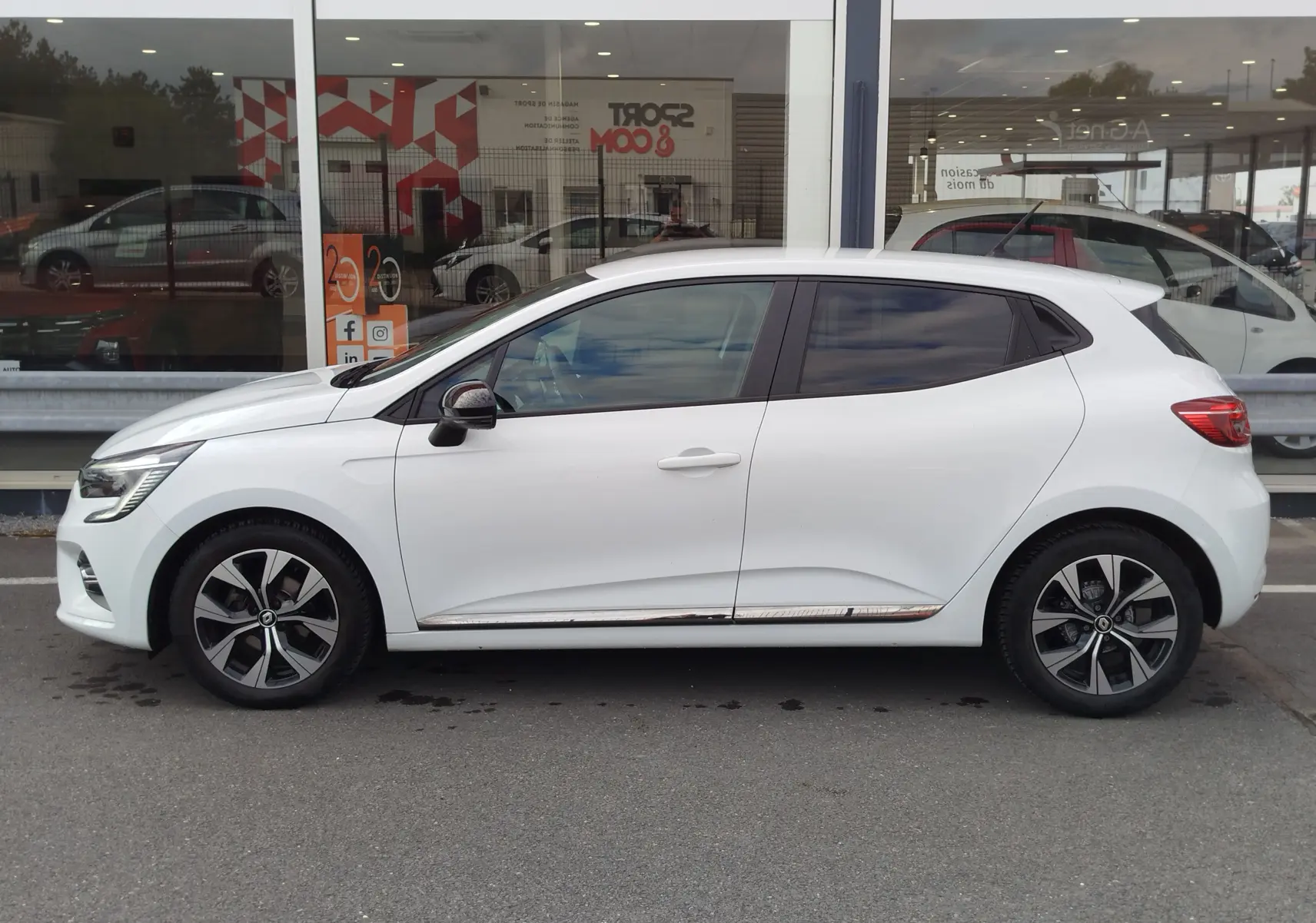 Profil côté gauche d'une Renault Clio 1.0 SCe 65ch Evolution blanche Glacier avec jantes alliage et vitres teintées.