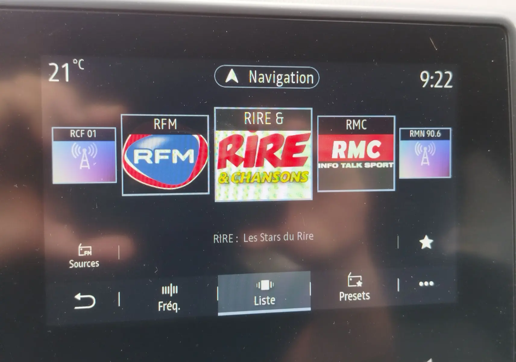 Écran tactile de la Renault Clio 2023 affichant les stations radio, avec navigation et température à 21°C.
