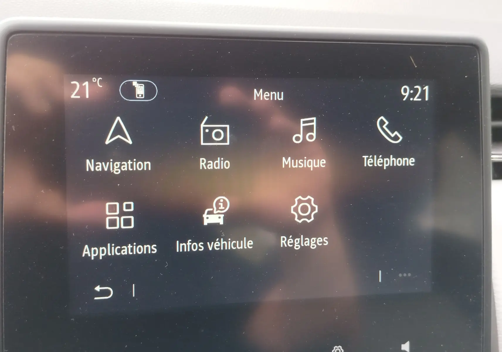 Écran tactile central de la Renault Clio 2023 affichant le menu principal avec navigation, radio, musique et téléphone.