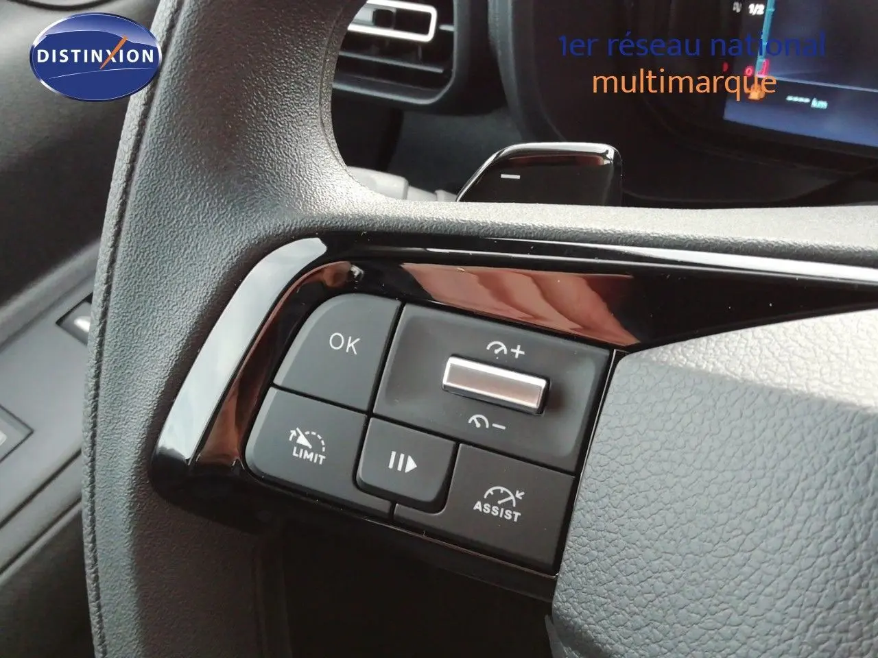 Gros plan sur les commandes au volant du Citroën Berlingo XL 2026, finition tissu gris avec boutons multifonctions noirs.