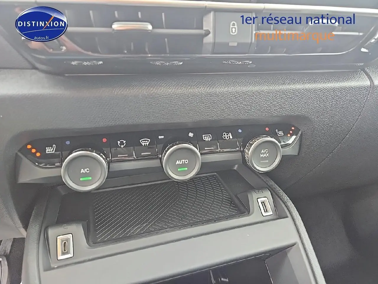 Vue rapprochée de la console centrale de la Citroën C4 bleu eclipse, montrant les commandes de climatisation et prises USB.