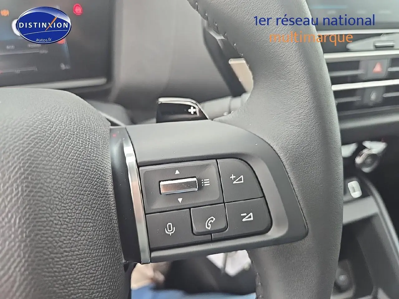 Gros plan sur les commandes audio et téléphone au volant en cuir noir de la Citroën C4 1.2 hybride 136 plus 2025.
