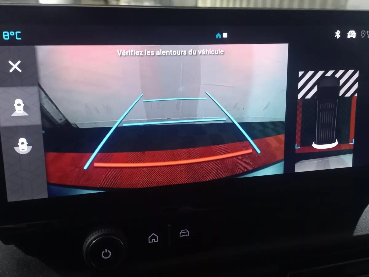 Vue de l'écran de caméra de recul du Citroën Berlingo blanc, affichant les lignes de guidage colorées et la zone arrière du véhicule.