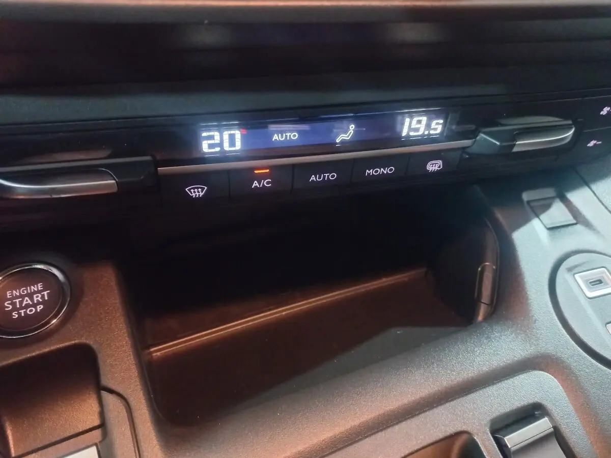 Gros plan sur la console centrale noire du Citroën Berlingo XL 2025, affichage digital de la climatisation et bouton start/stop.