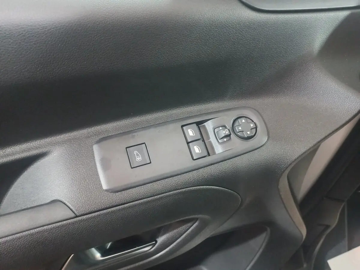 Gros plan sur les commandes de lève-vitres et rétroviseurs côté conducteur du Citroën Berlingo XL blanc 2025.