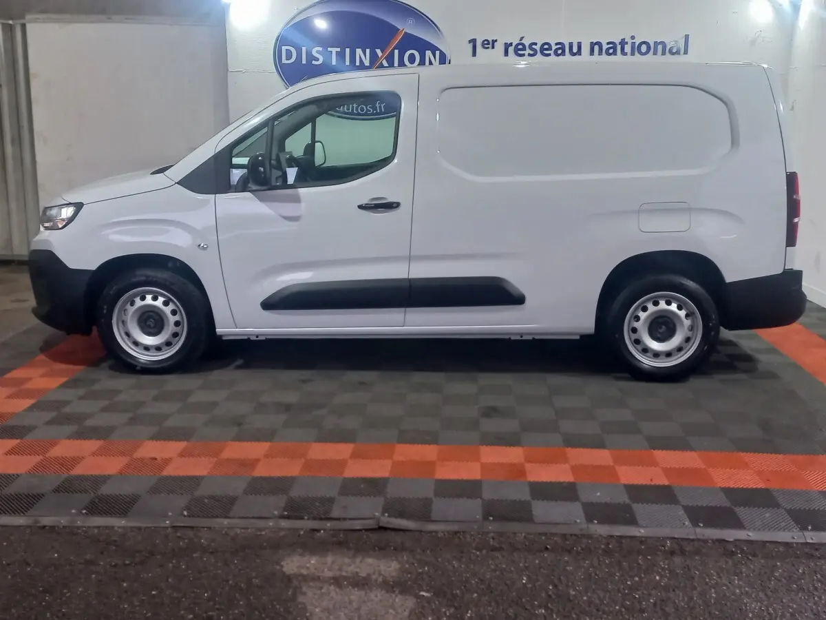 Vue latérale droite d’un utilitaire Citroën Berlingo XL blanc avec protections noires et jantes acier.