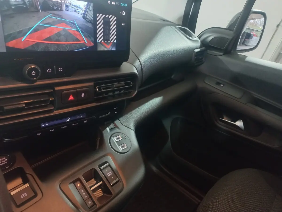 Vue intérieure côté passager du Citroën Berlingo blanc 2025, avec écran tactile et commandes de climatisation visibles.