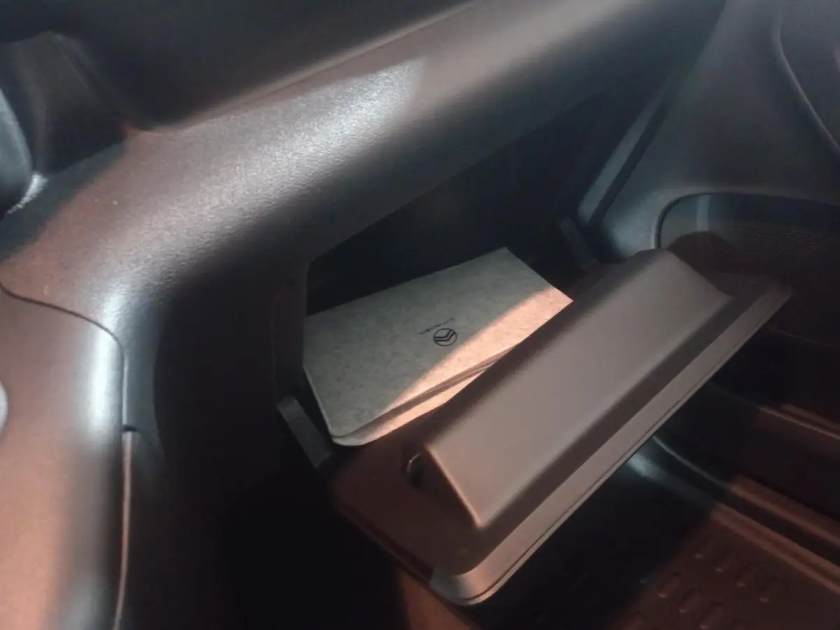 Vue intérieure sur la boîte à gants ouverte du Citroën Berlingo XL blanc 2025 avec manuel visible.