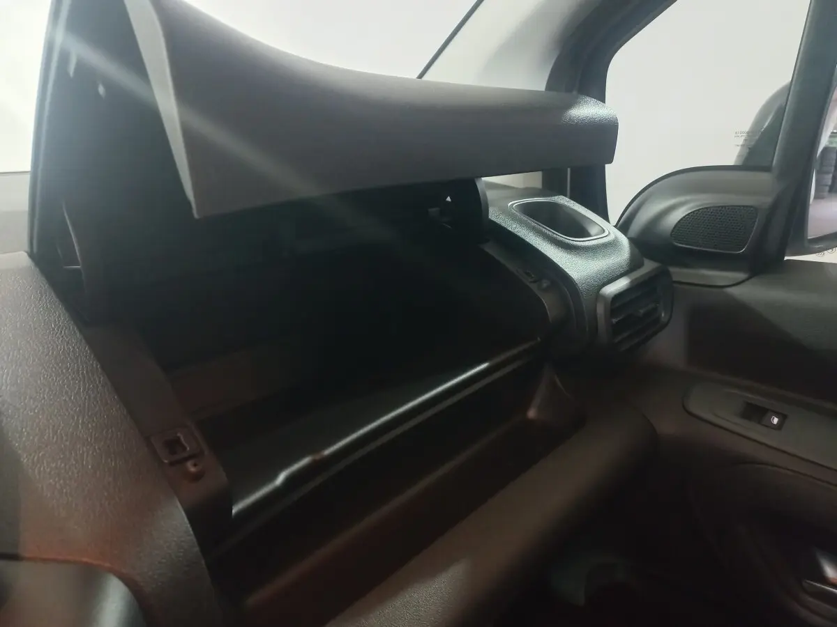 Vue intérieure côté passager du Citroën Berlingo XL blanc 2025, avec boîte à gants ouverte et aérateur visible.