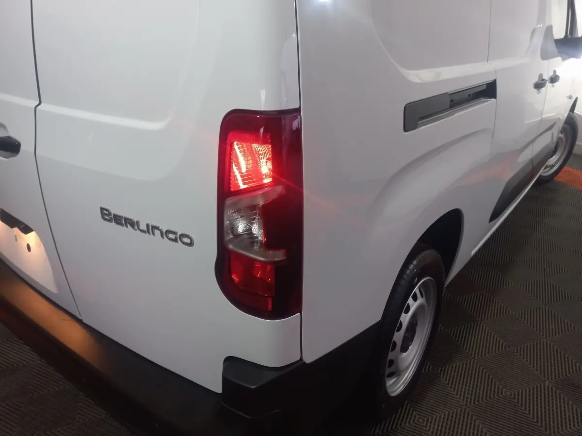 Vue arrière droite du Citroën Berlingo blanc XL avec feu arrière allumé et logo Berlingo visible.