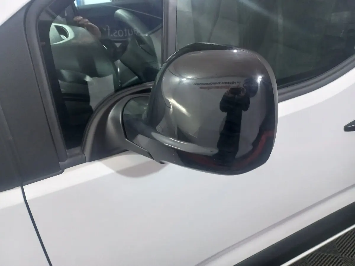 Rétroviseur noir côté conducteur d'un Citroën Berlingo XL blanc, vue rapprochée sur la portière avant.