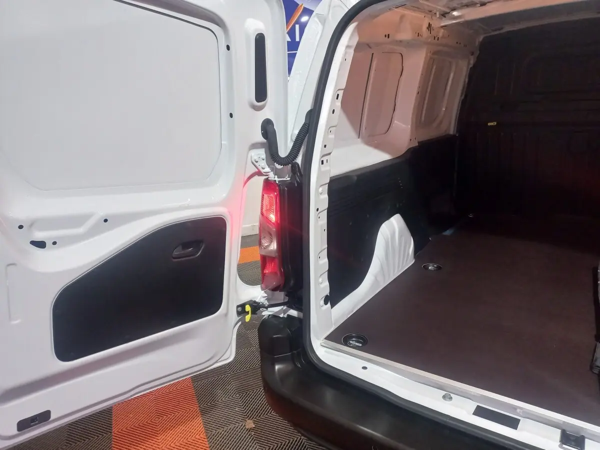 Vue intérieure arrière du Citroën Berlingo XL blanc, montrant la porte ouverte et l'espace de chargement vide.