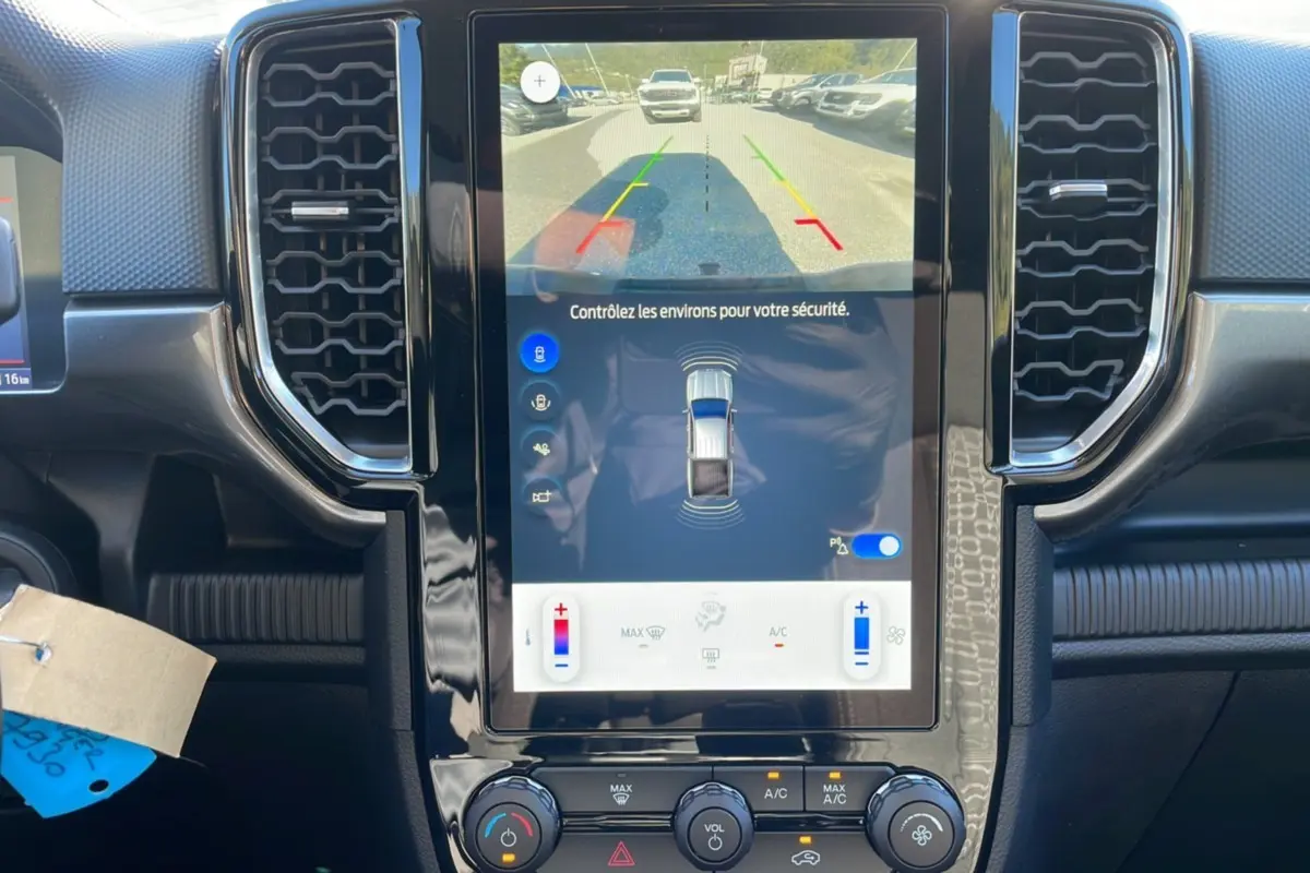 Vue rapprochée de l’écran tactile central du Ford Ranger 2025 gris iconic montrant la caméra de recul et les commandes climatisation.