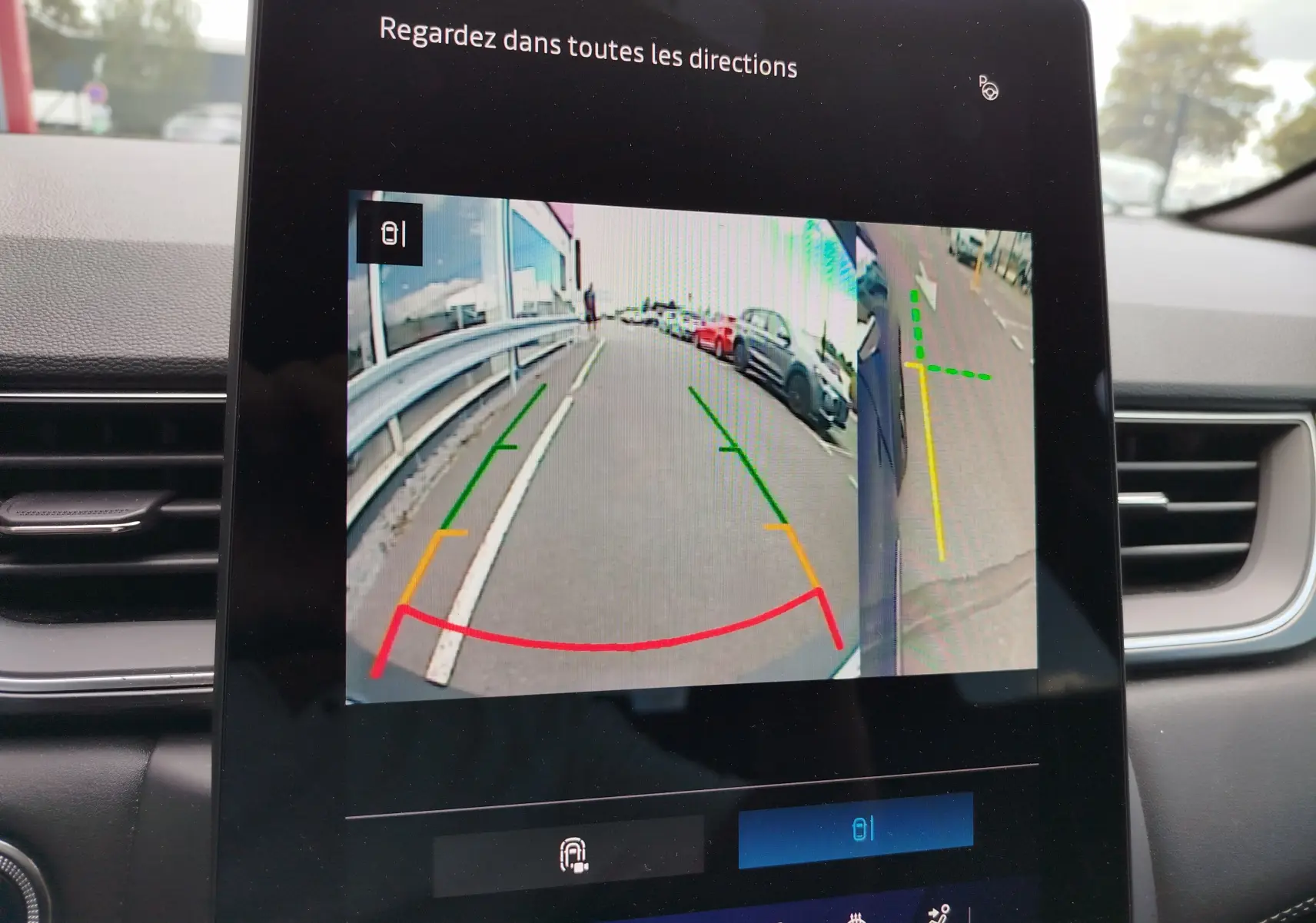 Écran intérieur de la Renault Symbioz 2025 montrant la caméra de recul avec lignes de guidage colorées.