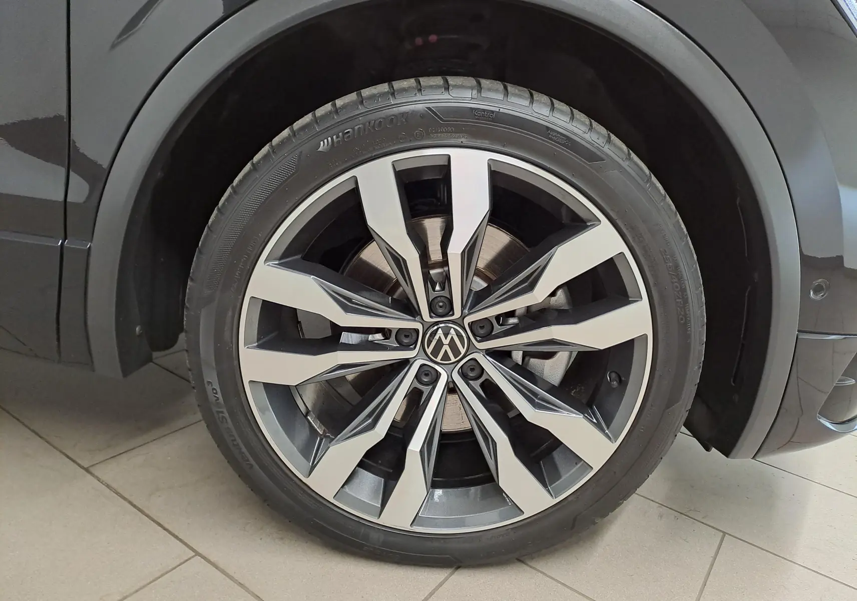 Gros plan sur la jante alliage 20'' Suzuka du côté avant droit du Volkswagen Tiguan noir intense nacré 2023.