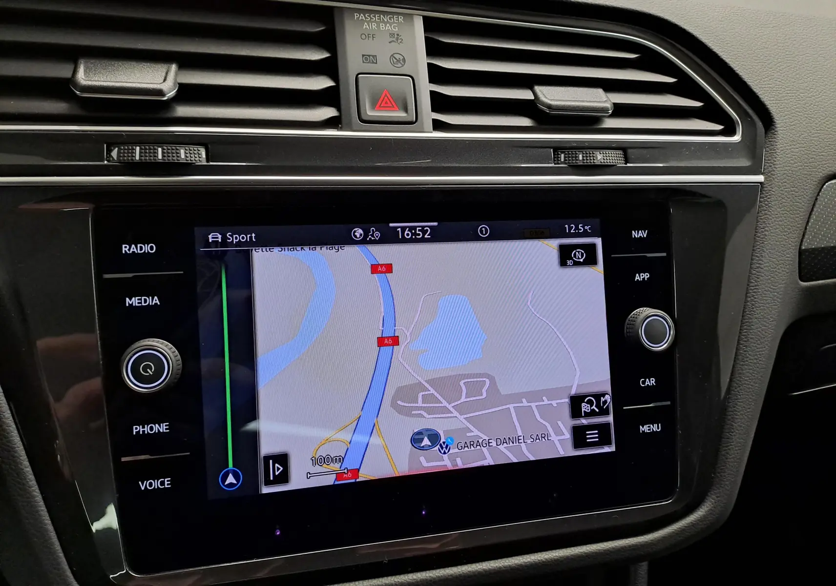 Vue rapprochée de l'écran tactile central du Volkswagen Tiguan 2023 avec navigation affichée, entouré de commandes noires.