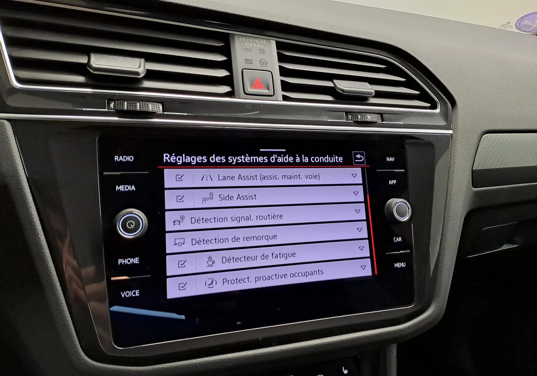 Écran tactile du système d'infodivertissement du Volkswagen Tiguan 2023 affichant les réglages d'aide à la conduite.