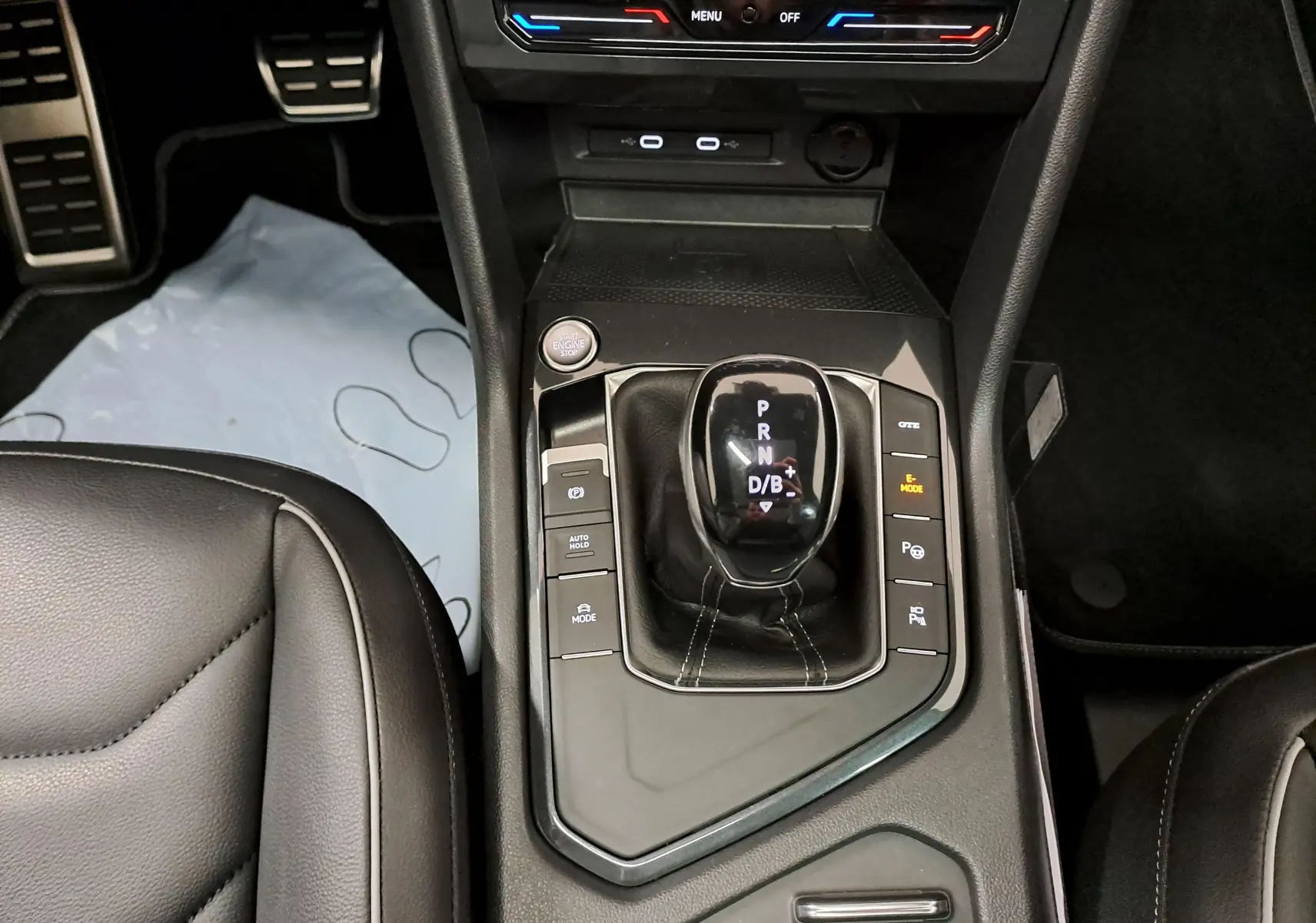 Vue plongeante sur la console centrale du Volkswagen Tiguan 1.4 eHybrid 2023 avec levier de vitesses automatique et boutons de contrôle.