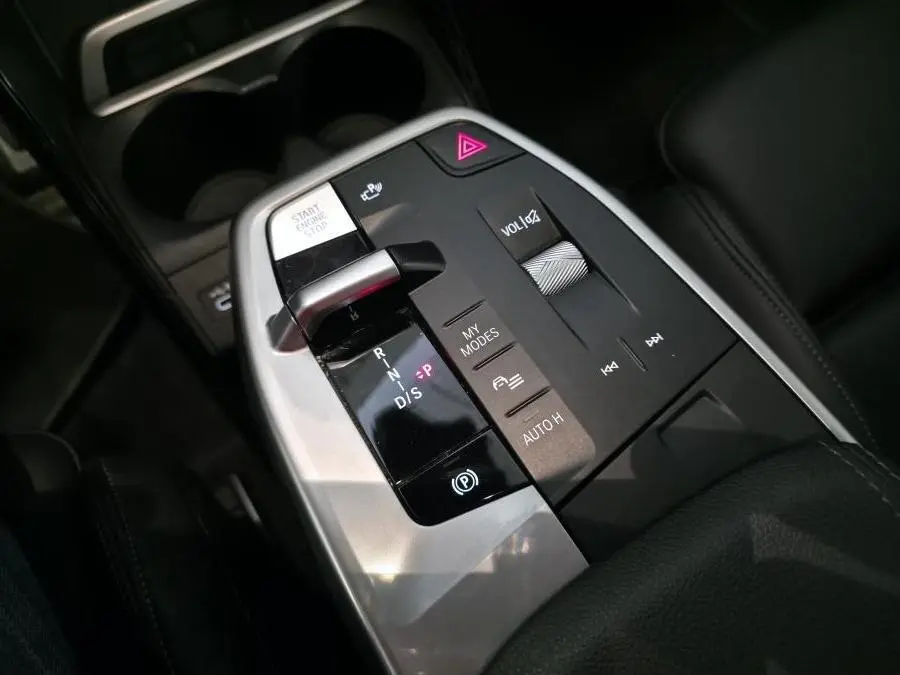 Gros plan sur la console centrale de la BMW Série 2 218i Active Tourer 2023, avec levier de vitesse et commandes intégrées.