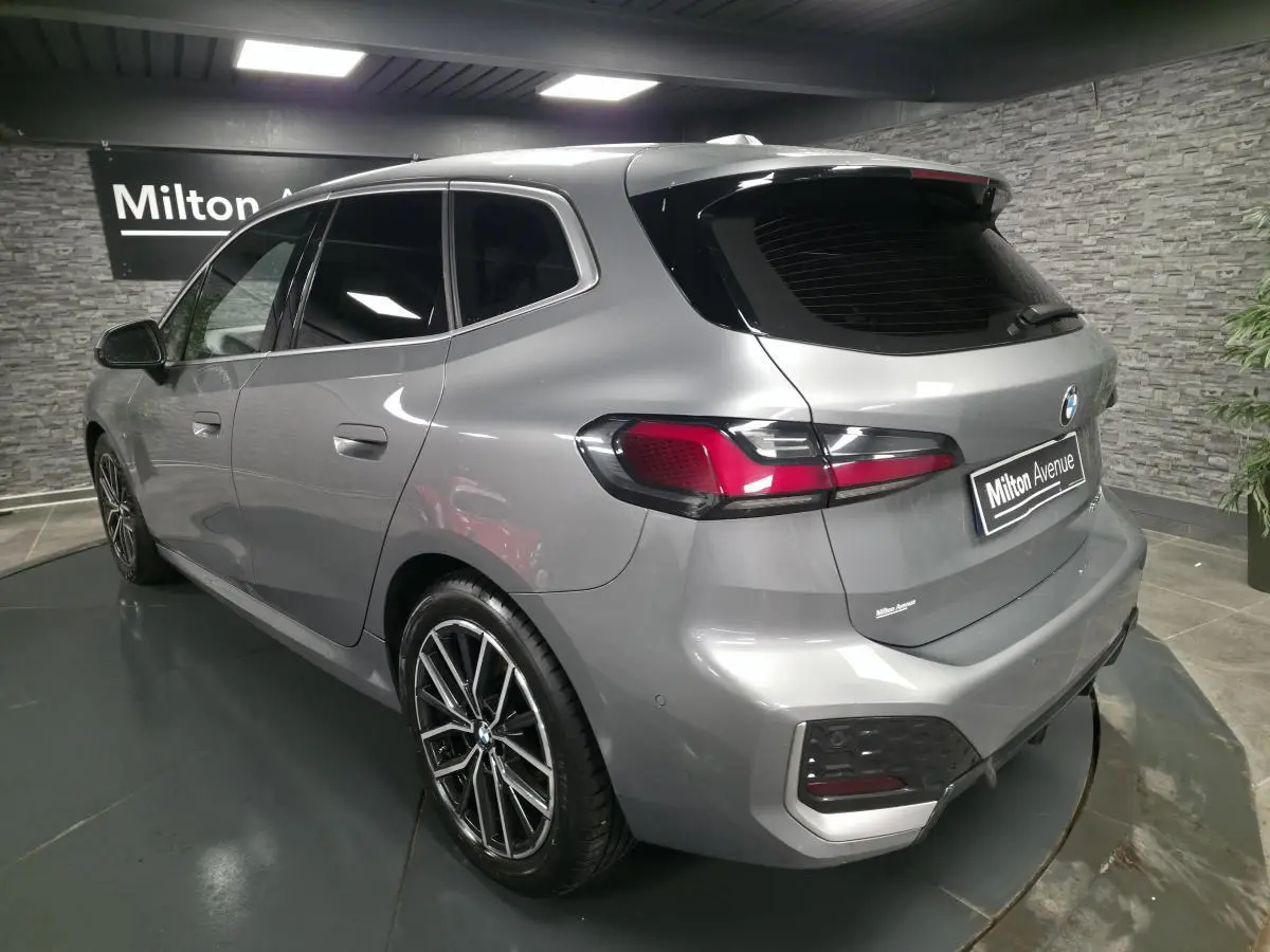 BMW Série 2 218i Active Tourer gris métallisé vue 3/4 arrière droit avec jantes alliage 18 pouces et feux LED.