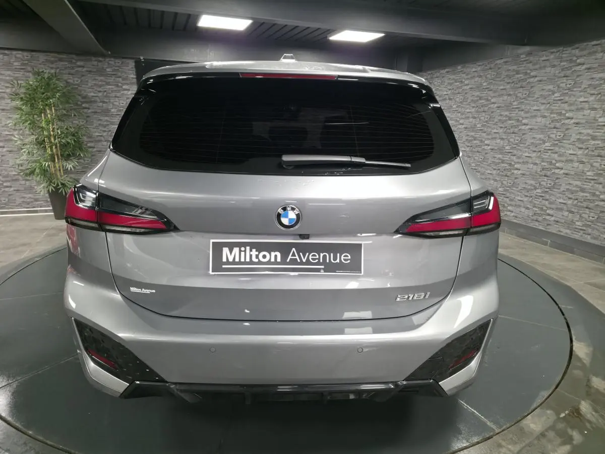 Vue arrière d'une BMW Série 2 218i Active Tourer grise métallisée avec feux LED et logo central sur hayon.