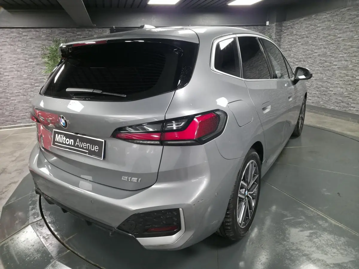 BMW Série 2 218i Active Tourer gris métallisé vue 3/4 arrière droit avec feux LED et jantes alliage 18 pouces.