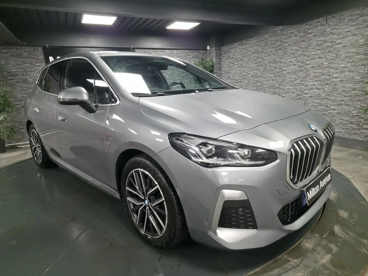BMW Série 2 218i Active Tourer gris métallisé vue 3/4 avant avec calandre verticale et jantes 18 pouces M bicolores.