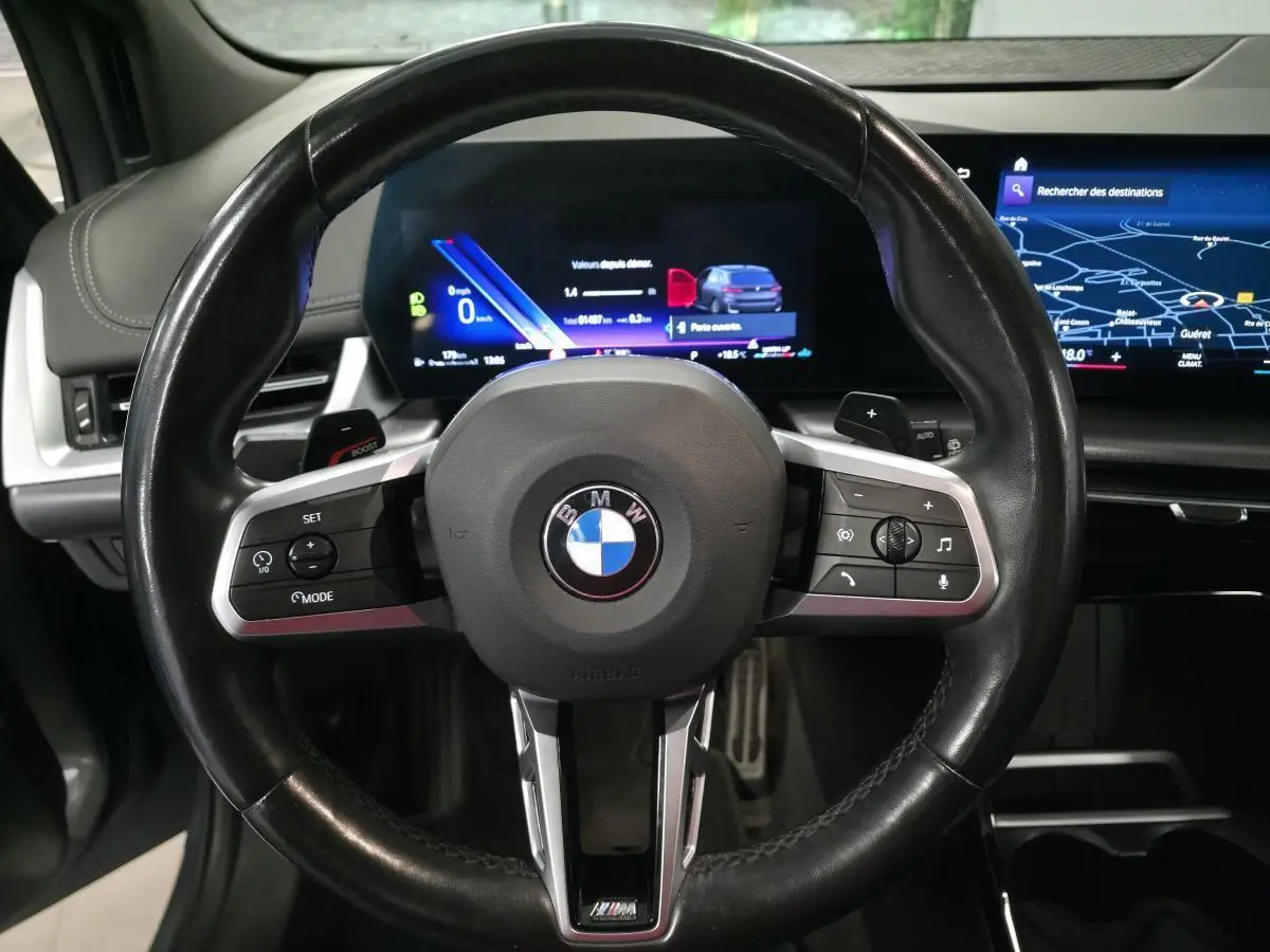 Volant cuir M de BMW Série 2 218i Active Tourer 2023 vu de face avec combiné numérique et écran tactile incurvé.